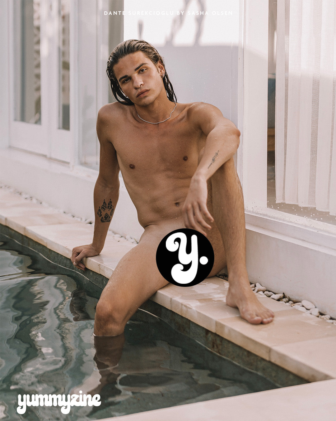 Naked guy sitting by a pool, partially covered, with a logo in the foreground.
